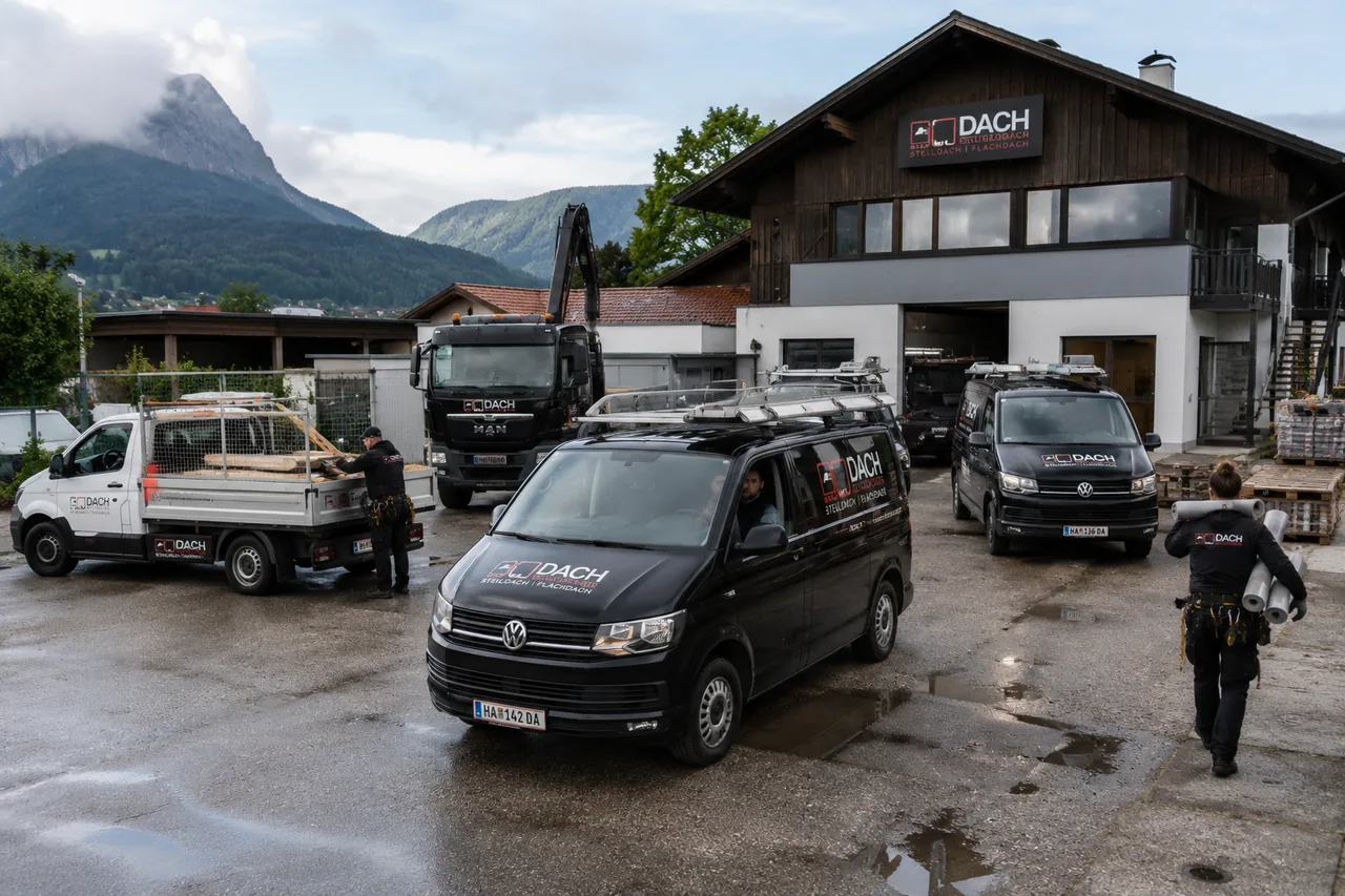 Gut ausgelasteter Dachdeckerbetrieb mit mehreren beschrifteten Firmenfahrzeugen und Mitarbeitern auf dem Betriebshof vor einer Bergkulisse als Zeichen voller Auftragsbücher trotz Konjunkturflaute.